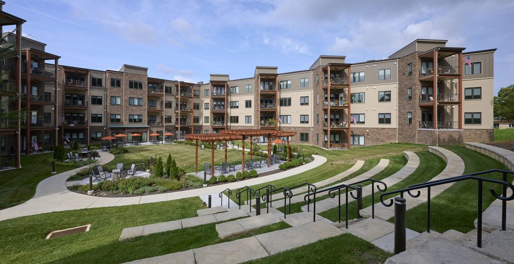 Amphitheater, pergola and walking path in front of apartment building