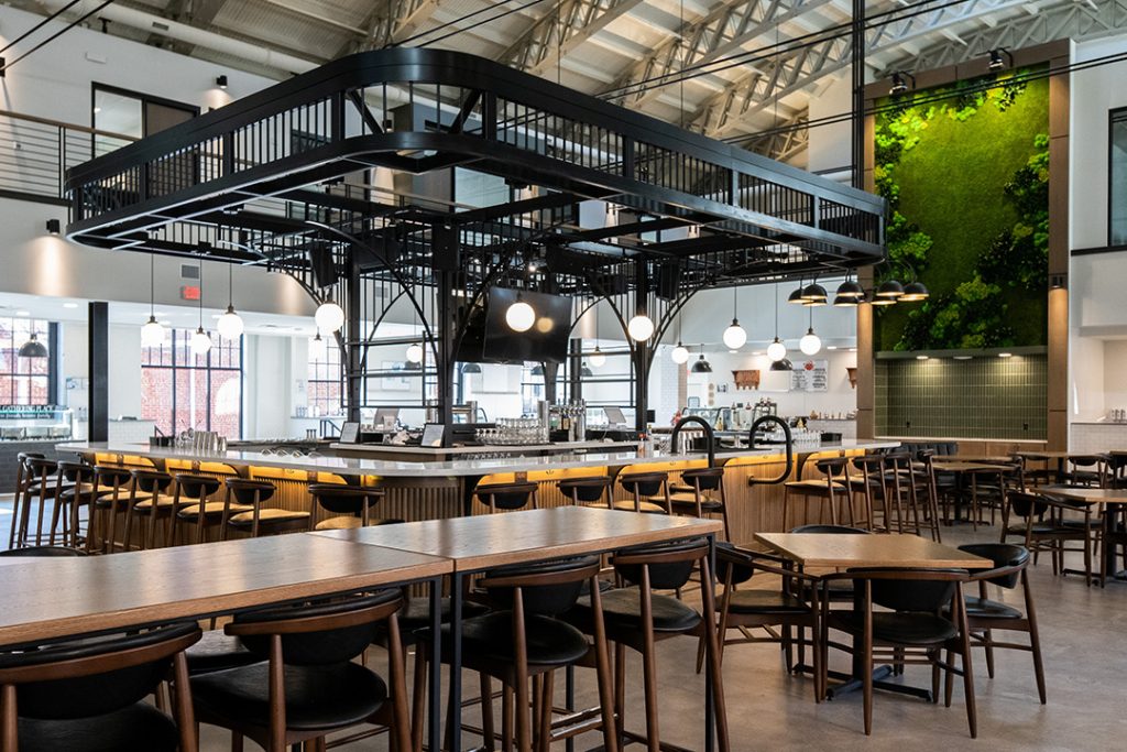 Though industrial in form, its detailing complements the wooden panels and light fixtures that surround the marbleized bar top.