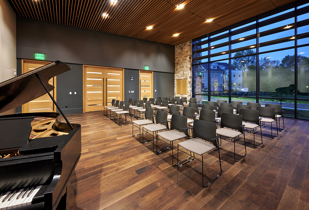 Theater has specific design components to define its primary purpose, but does not have a sloped floor or fixed seating so that it can also be used for meetings and classes which are held on a regular basis.  