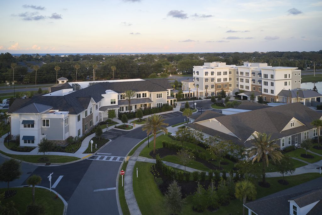 Aerial view of the Vicar’s Landing at Oak Bridge campus, showing several residential buildings connected by landscaped walkways and streets.