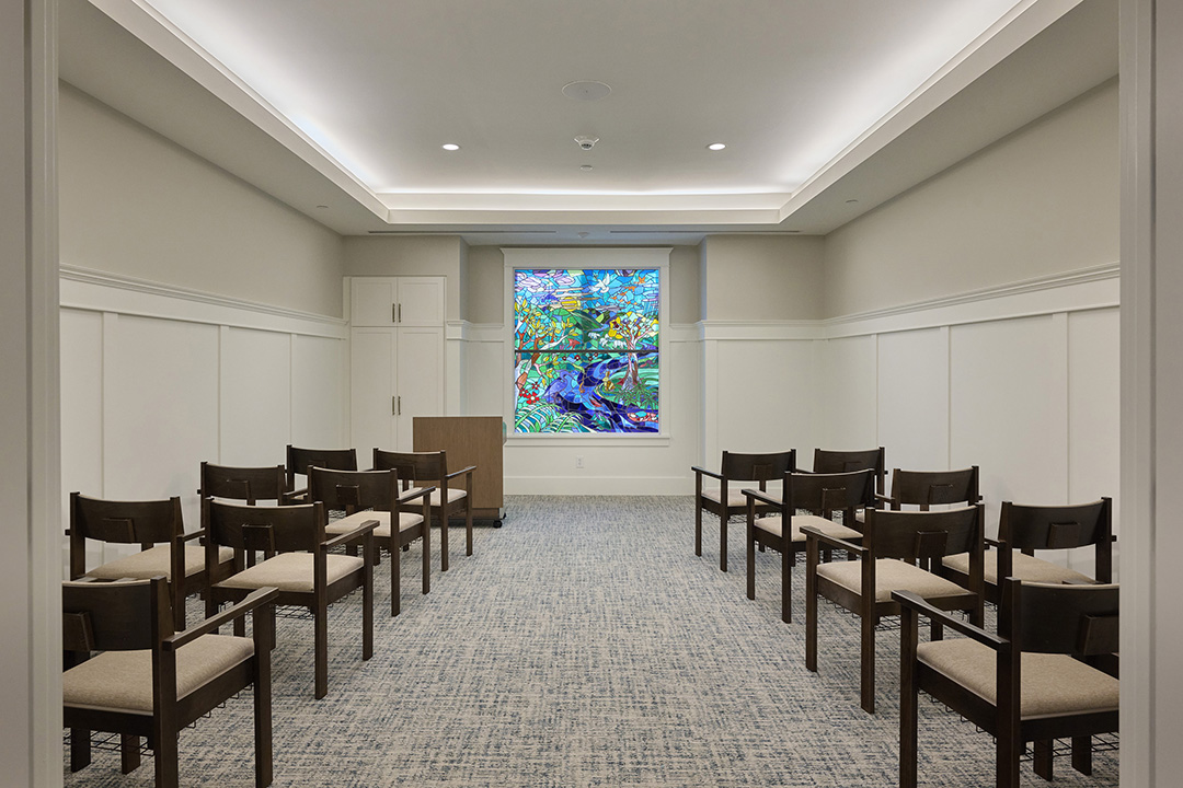 community chapel with chairs in two rows and a focal-point stained glass window