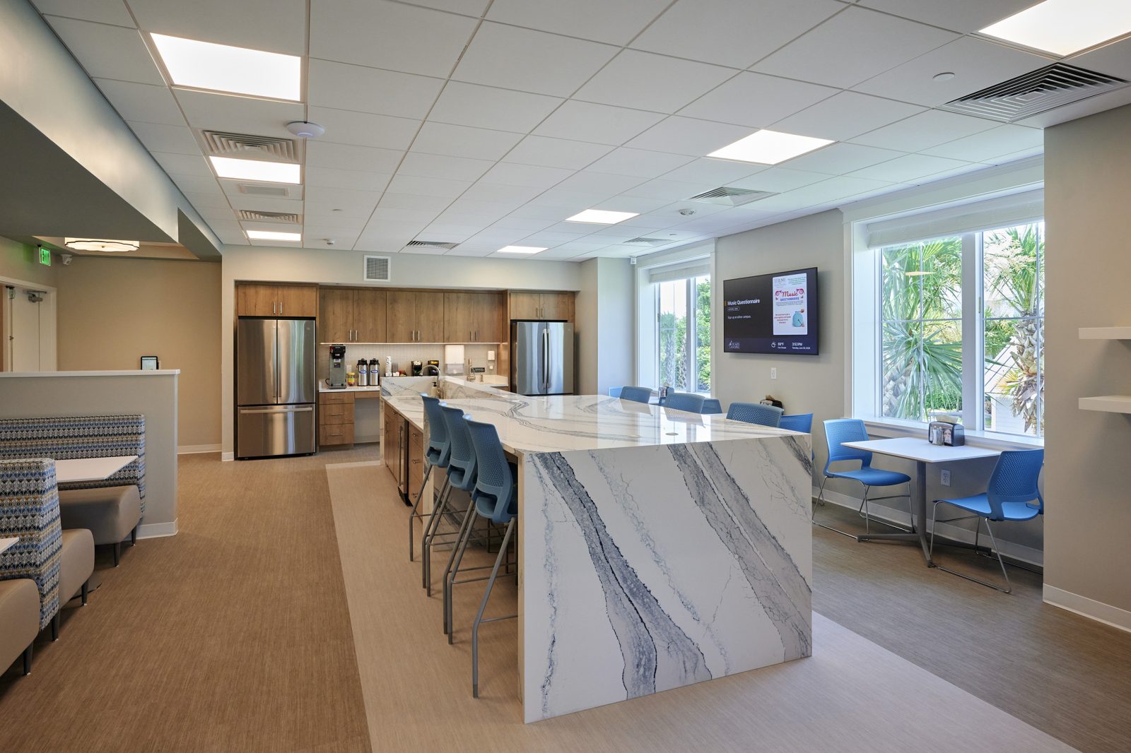 Staff break room with banquette seating and a marble-look waterfall island