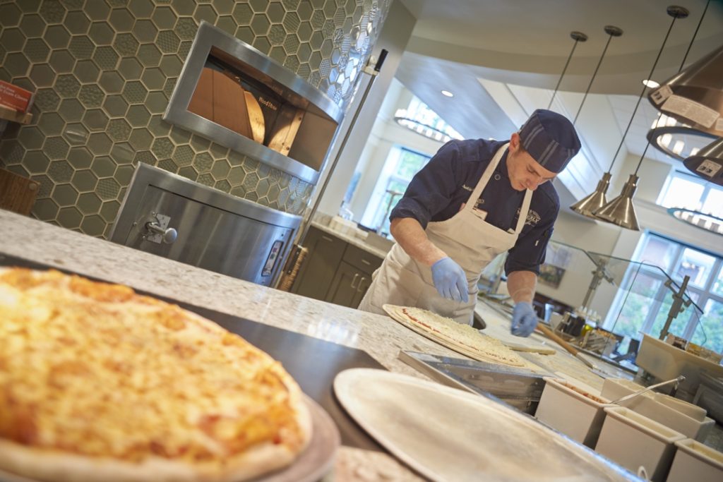 The ‘front and center’ display of food preparation, including the popular hearth oven, allows chefs to fully engage with community residents.