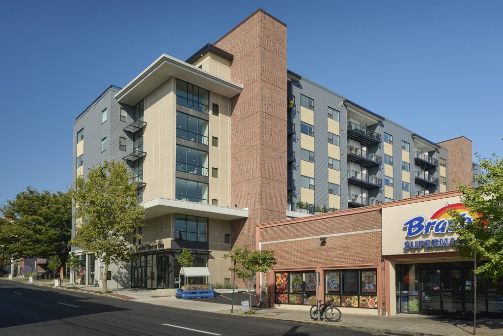 Contemporary apartment building next to a grocery store in downtown streetscape