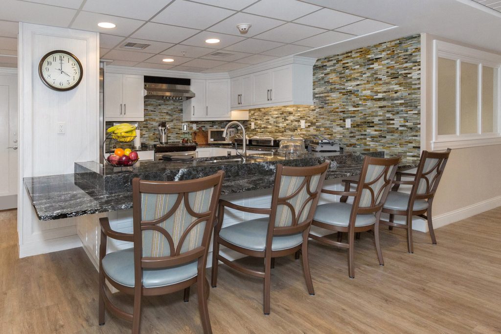 white kitchen with stone accents and chairs at breakfast bar