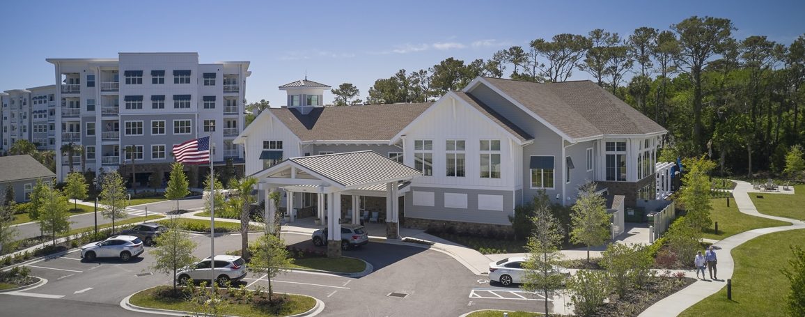 Aerial view of white clubhouse and apartment buildings in Florida