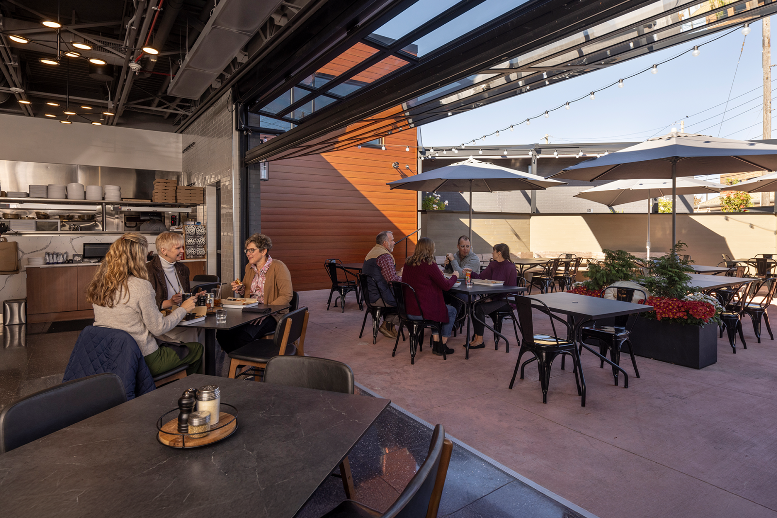An upscale restaurant with indoor outdoor dining via a raised garage door