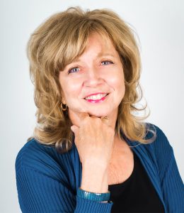 headshot of a woman in a black shirt and blue cardigan