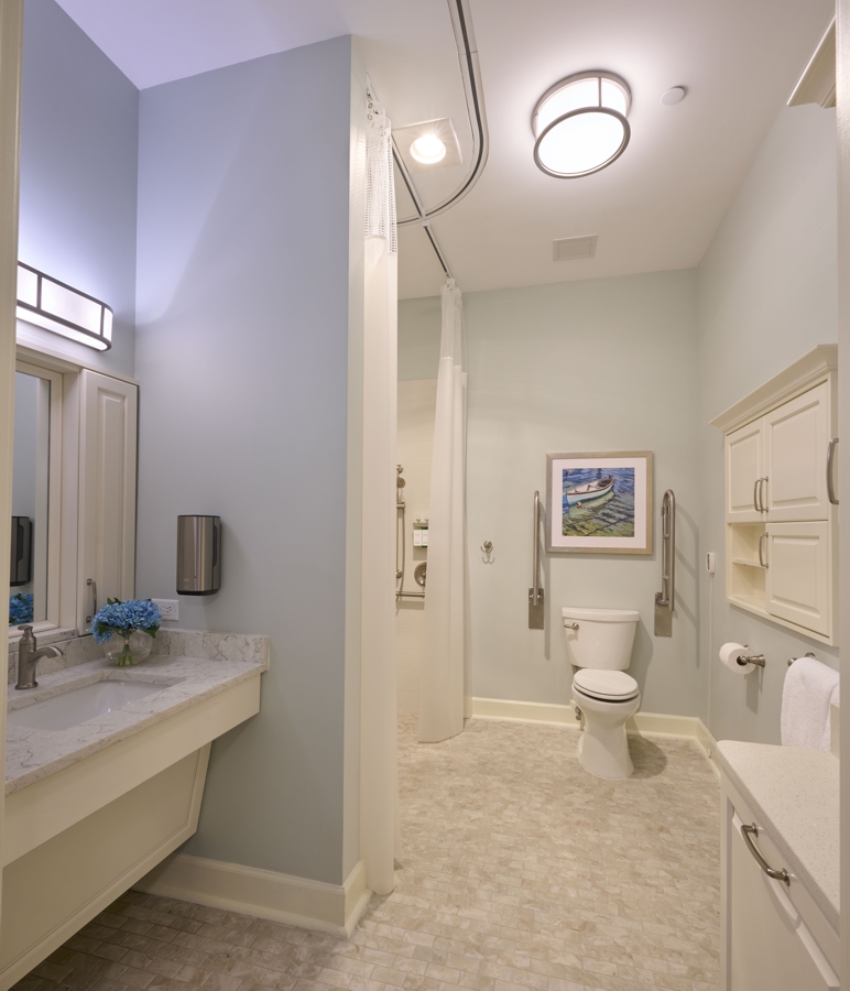 Bathroom for persons of size in senior care facility with lift, accessible shower and sink