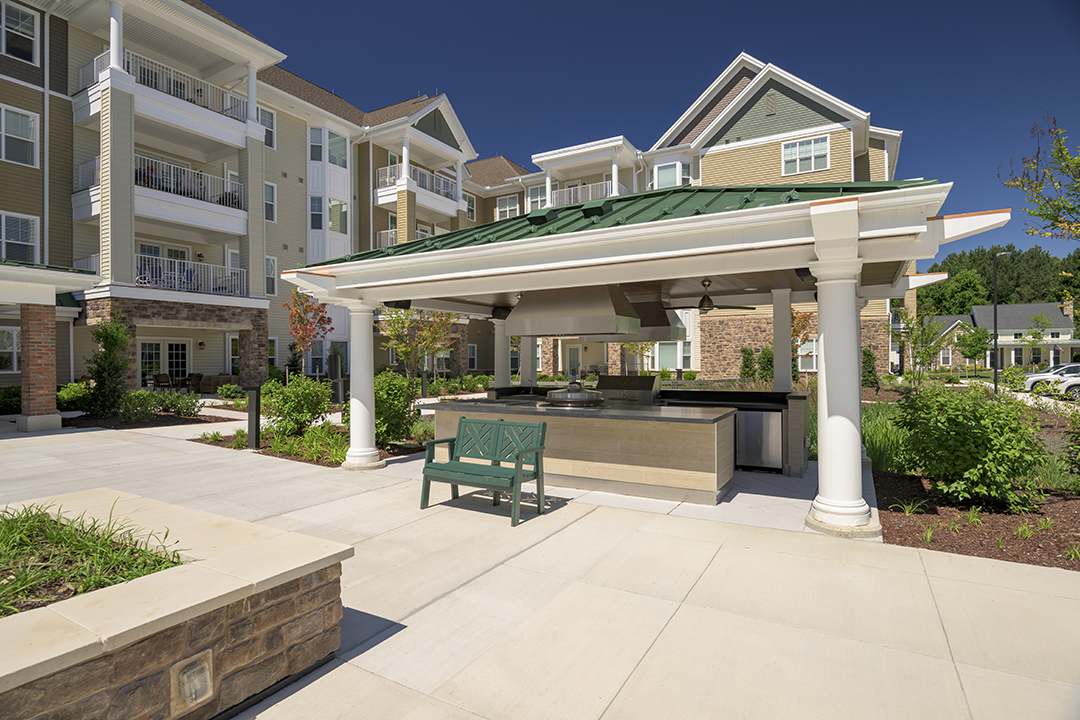 Outdoor kitchen and patio in front of apartment building