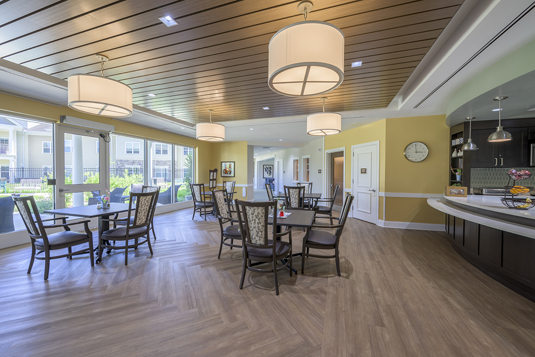 Dining area with wood ceiling and tables in front of a window wall