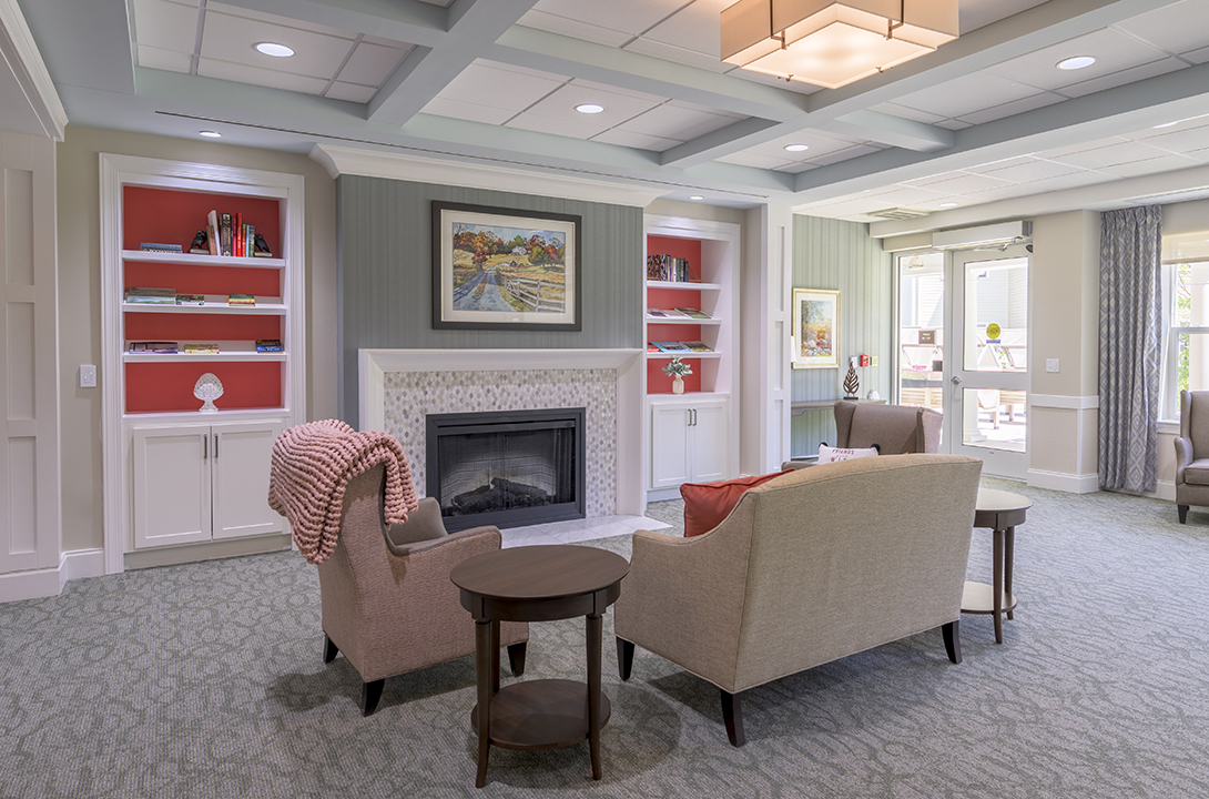 Living room with fireplace surrounded by bookshelves with red accents
