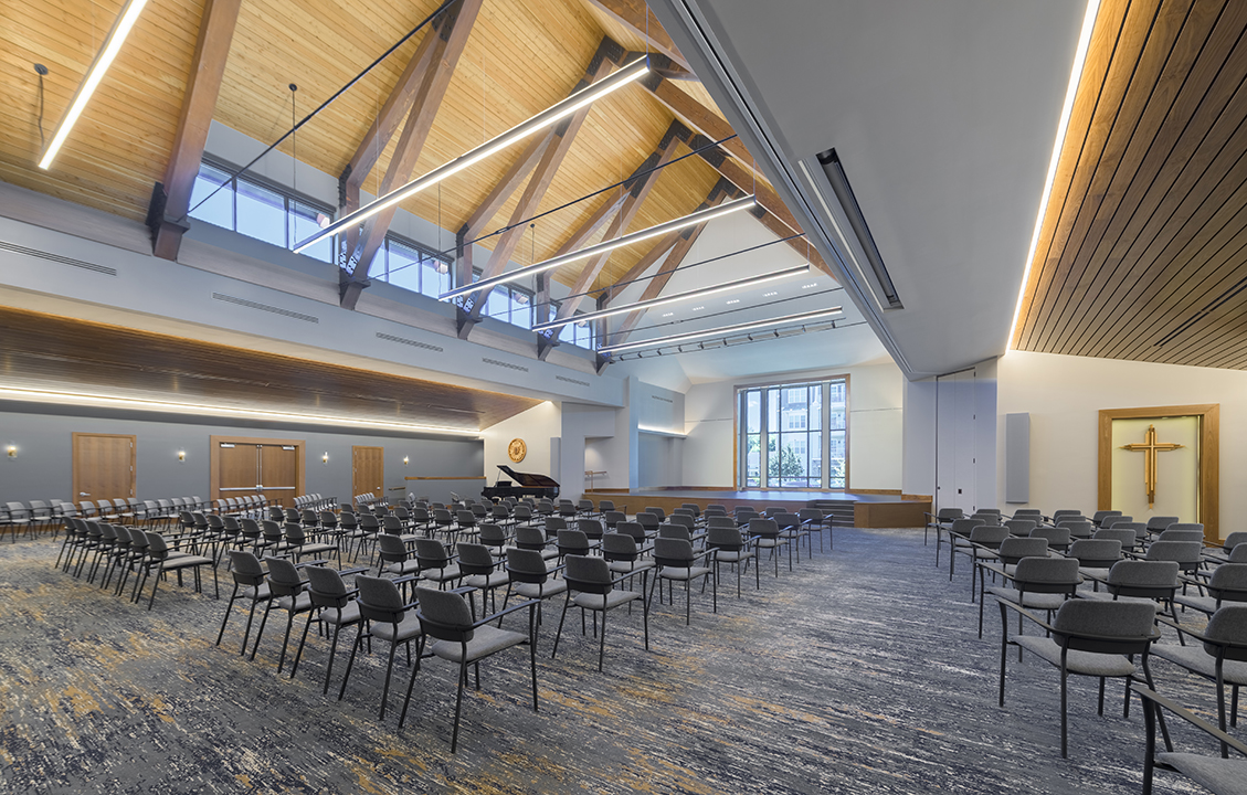 Combination Performing Arts Center and chapel with rows of chairs vaulted wood ceiling