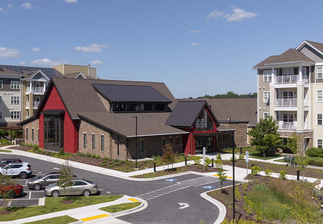 Exterior view of the Performing Arts Center and Chapel at Lutheran Village at Miller's Grant, with landscaped entrance, parking area, and adjacent independent living apartments.