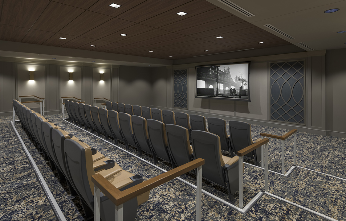 Darkened theater with tiered seating and black and white movie on screen