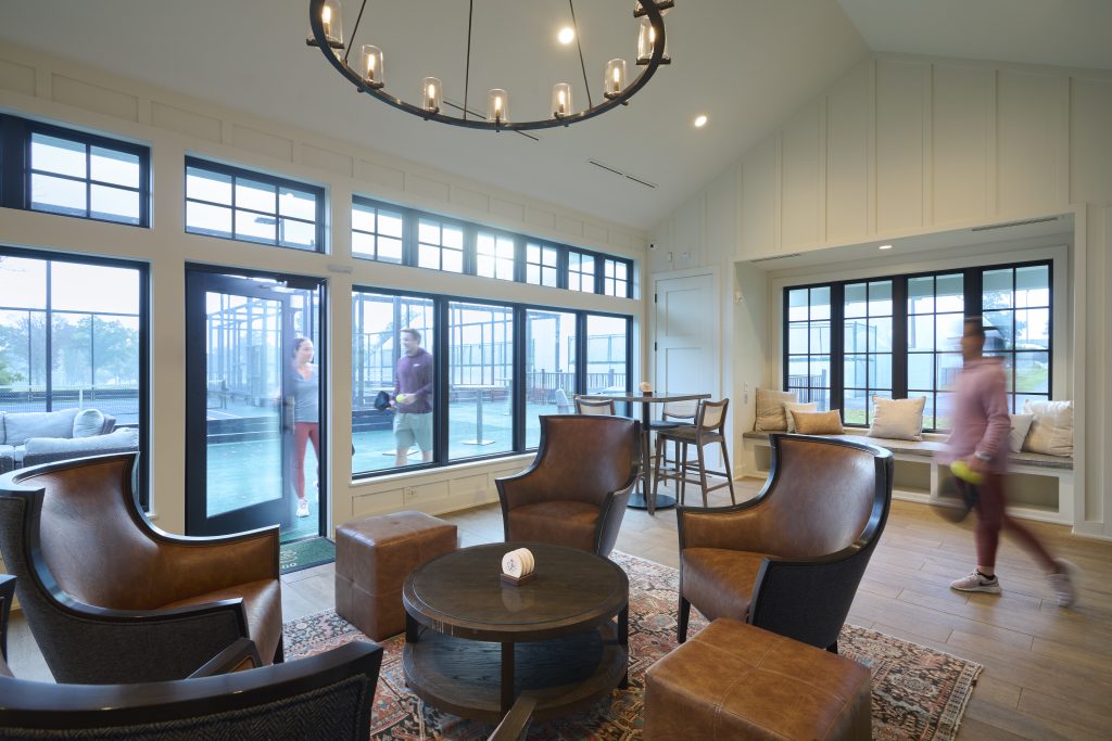 country club interior lounge area with windows facing racquets courts