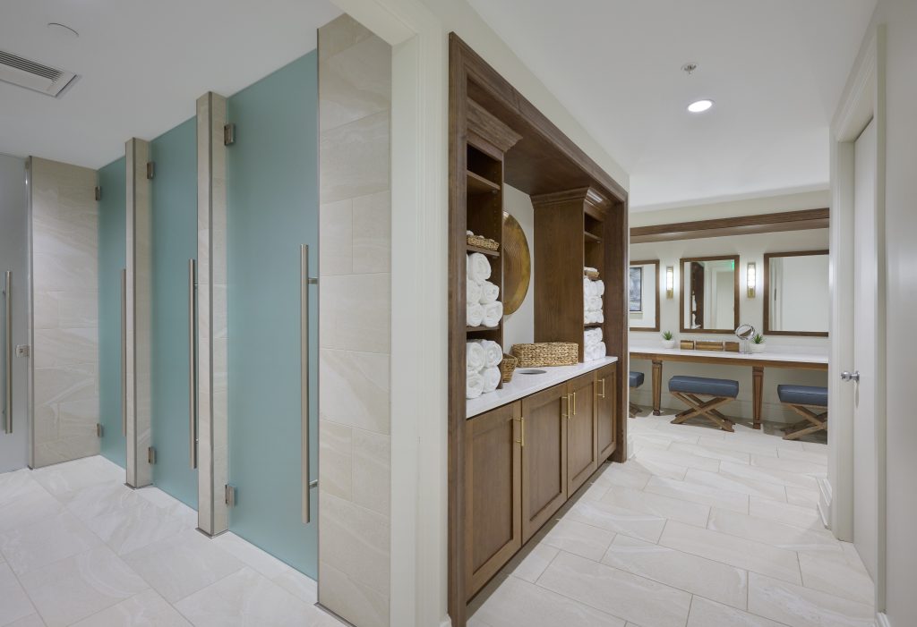 high end women's locker room with wood cabinets and frosted glass