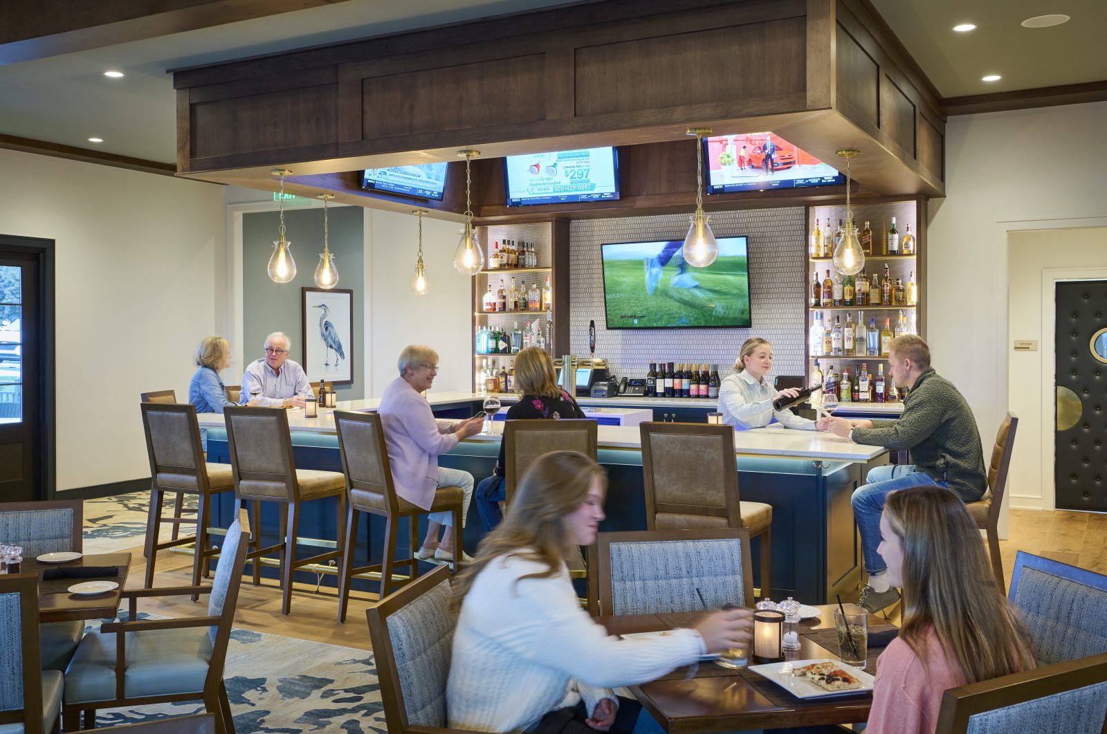 Bar with wood paneling and tables in foreground